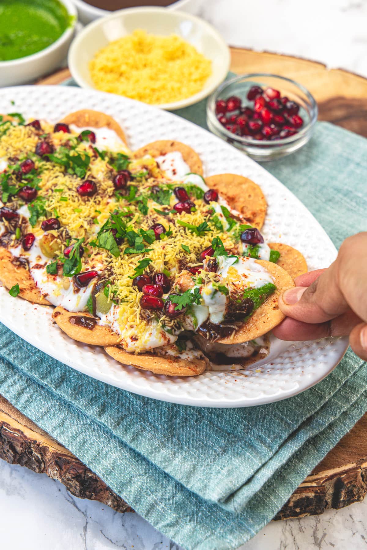 Take a piece of dahi papdi chaat from the plate.