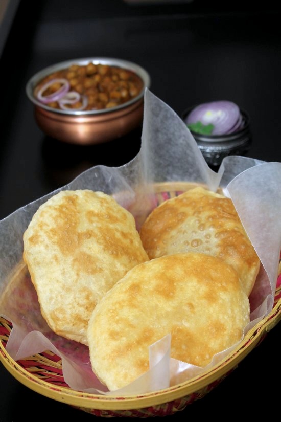 3 bhatura in a parchment paper lined basket.