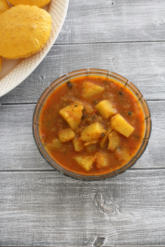 Aloo tamatar ki sabzi in a glass bowl.