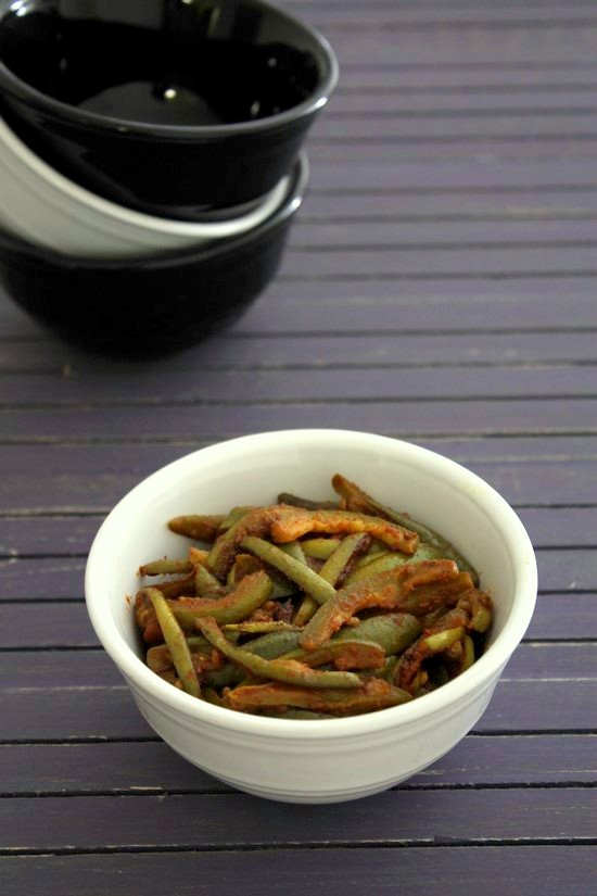 Parwal ki sabzi in a bowl and a stack of empty bowl in the back.