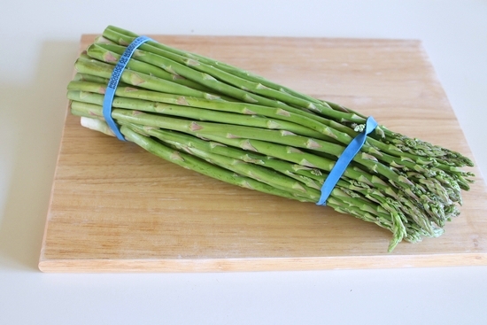 a bunch of asparagus on a cutting board.