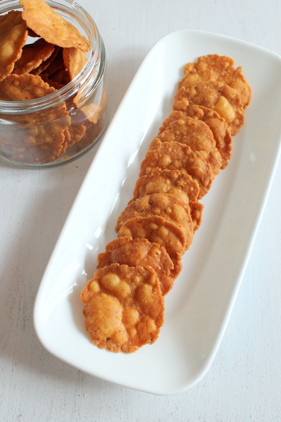 Crispy masala puri served in a plate and a few more in the container.