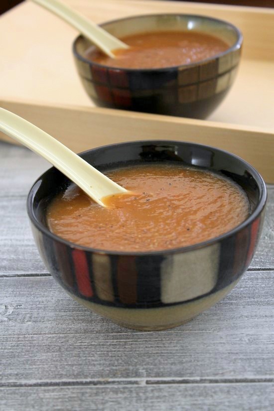 2 bowls of mixed vegetable soup with spoons inside.