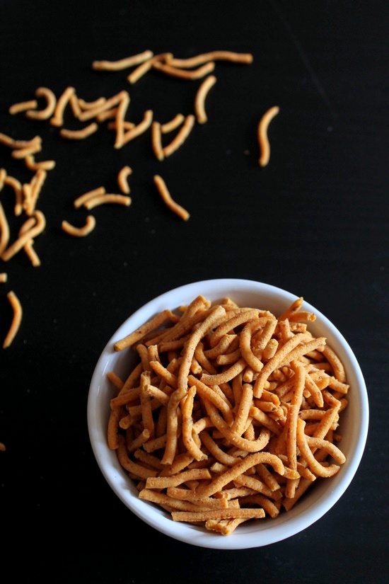 Tikha gathiya in a bowl and a few scattered around.