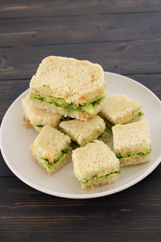Chutney Sandwich pieces in a plate with a stack of cucumber chutney sandwich.