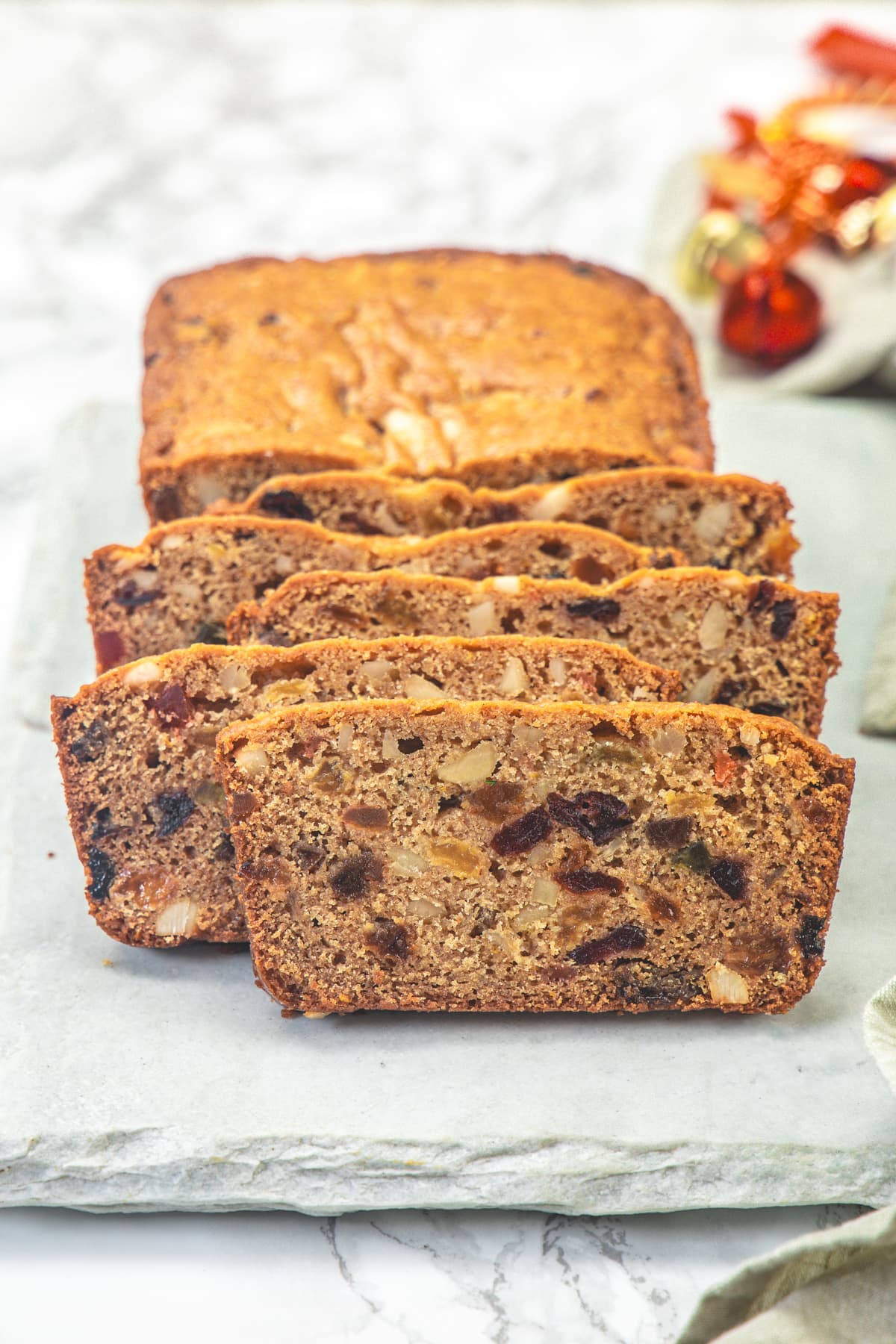 Slices of eggless fruit cake on a marble board.