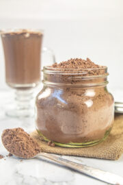 Hot chocolate mix in a jar with a spoon full on the side.