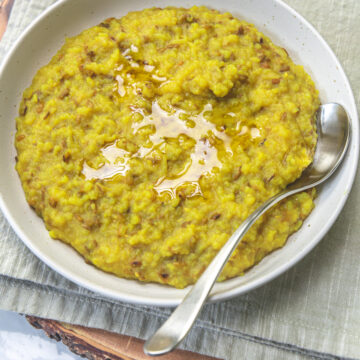 Gujarati khichdi served in a plate, topped with ghee.