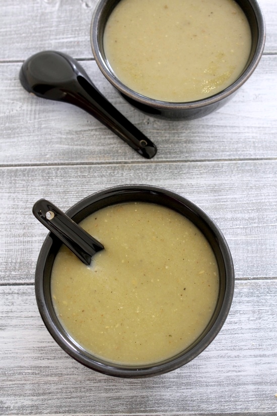 2 bowls of lauki soup with soup spoons on the side.