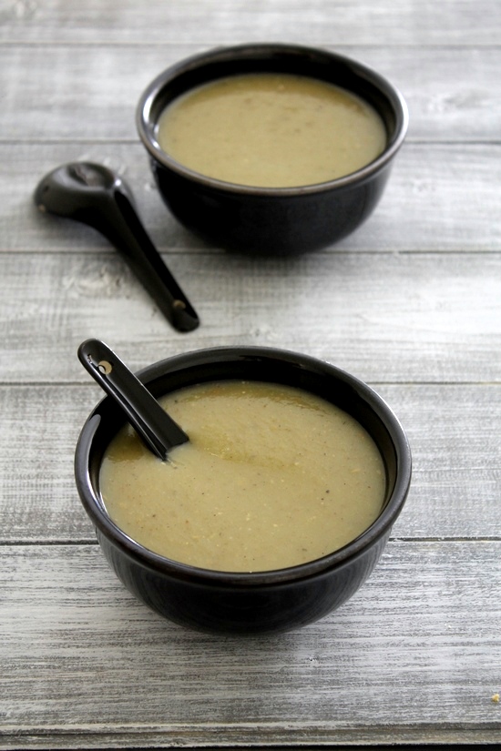 Lauki soup in a bowl with spoon inside and another bowl and spoon in the back.