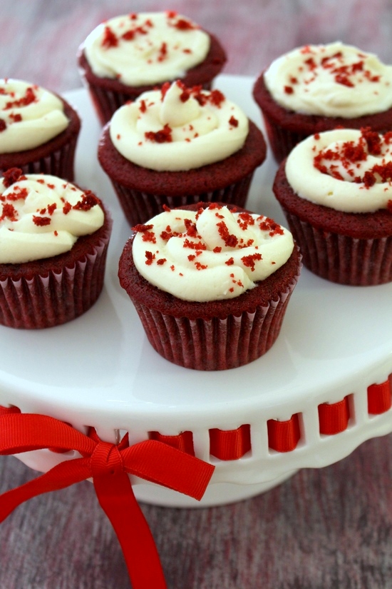 Eggless red velvet cupcakes on a cupcake stand with red ribbon.