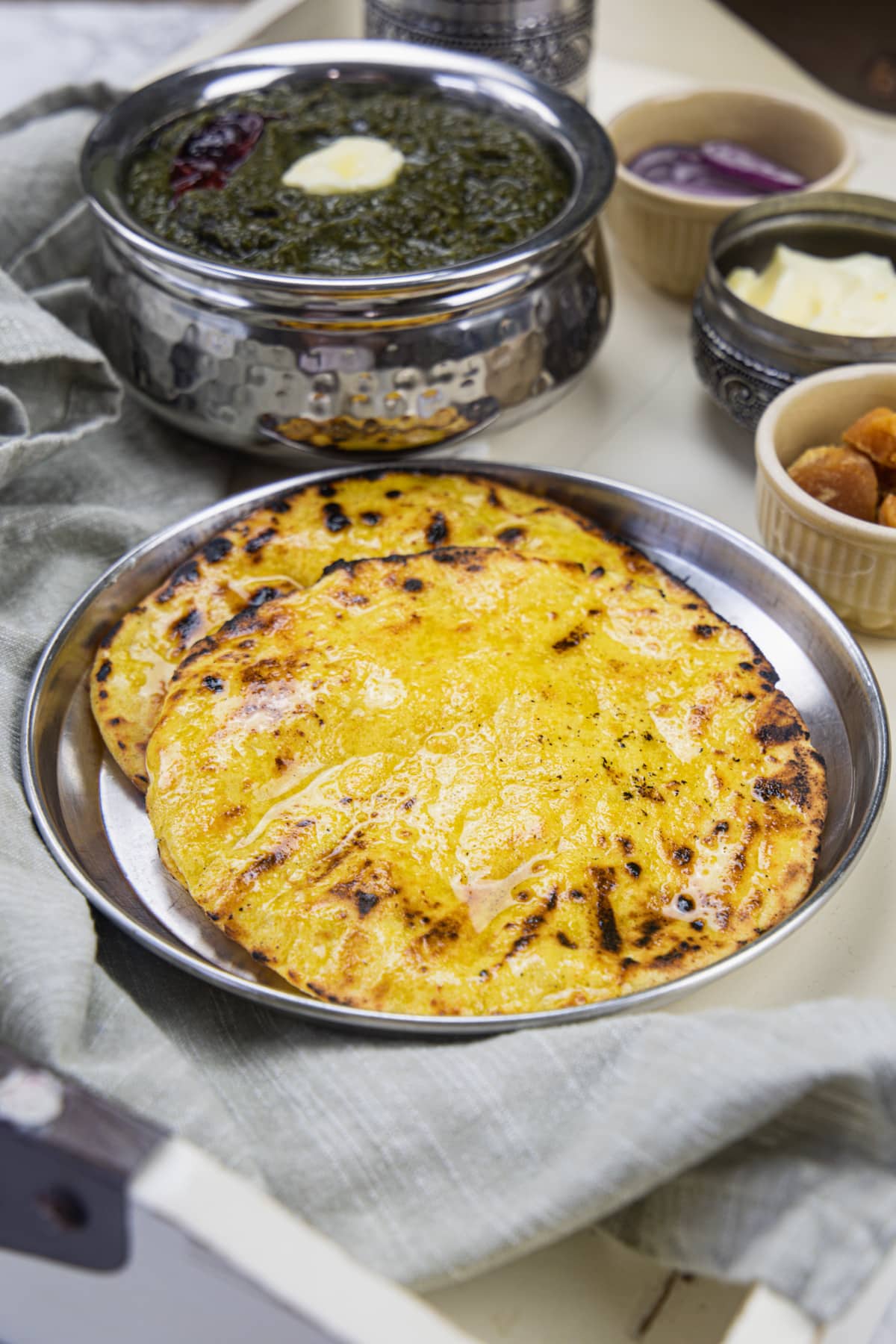 2 makki ki roti with sides of sarson ka saaf, jaggery, butter and onion.