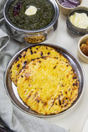 2 makki ki roti in a steel plate with saag.