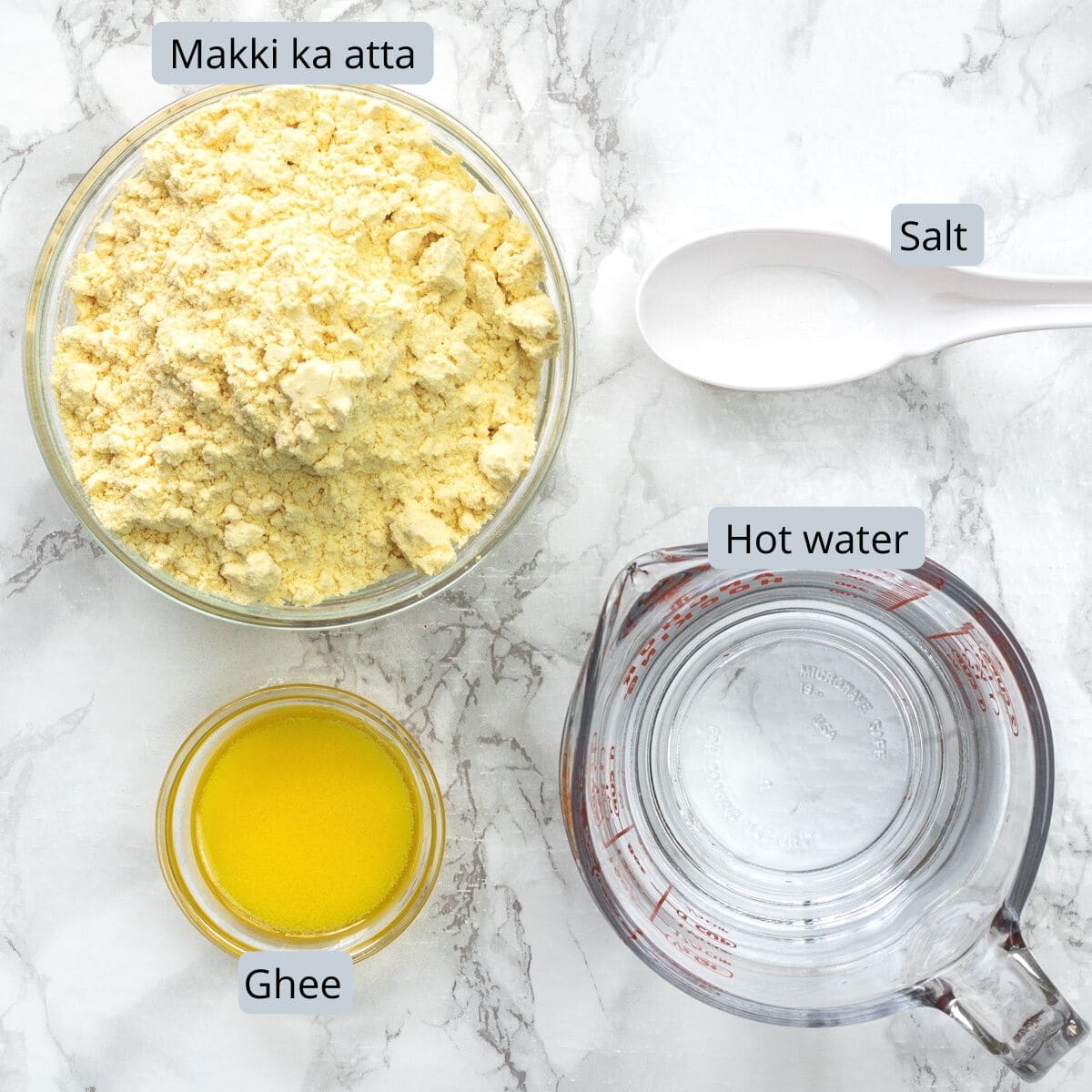 Makki ki roti ingredients in bowls and cups with labels.
