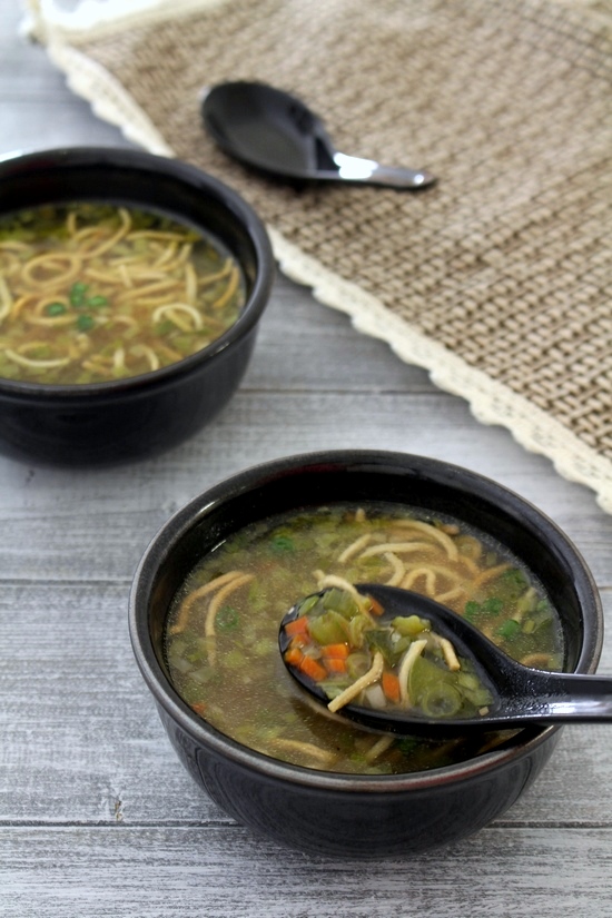 A spoonful of veg manchow soup is taking from the bowl.