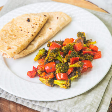 A plate with broccoli sabzi and 2 rotis.