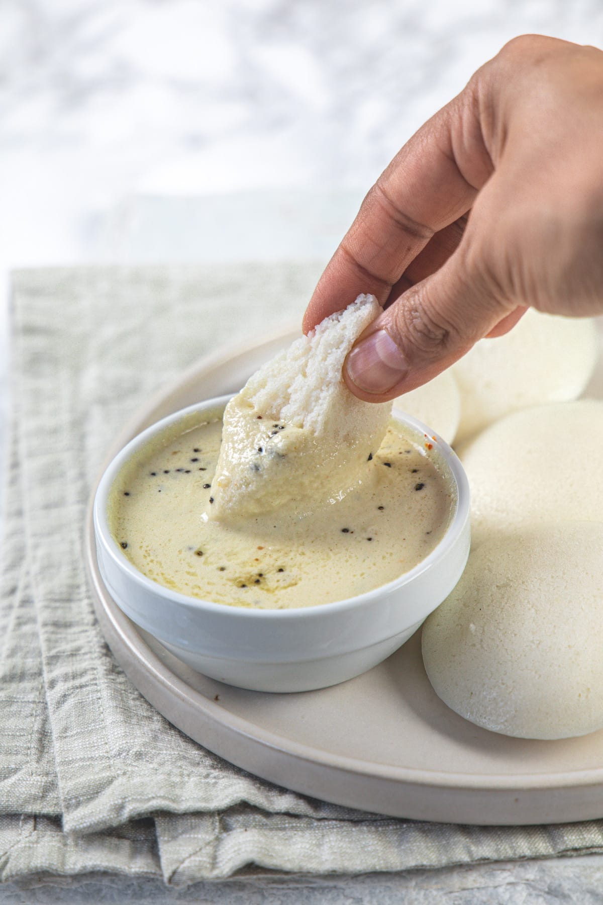 Idli dipped in coconit chutney.