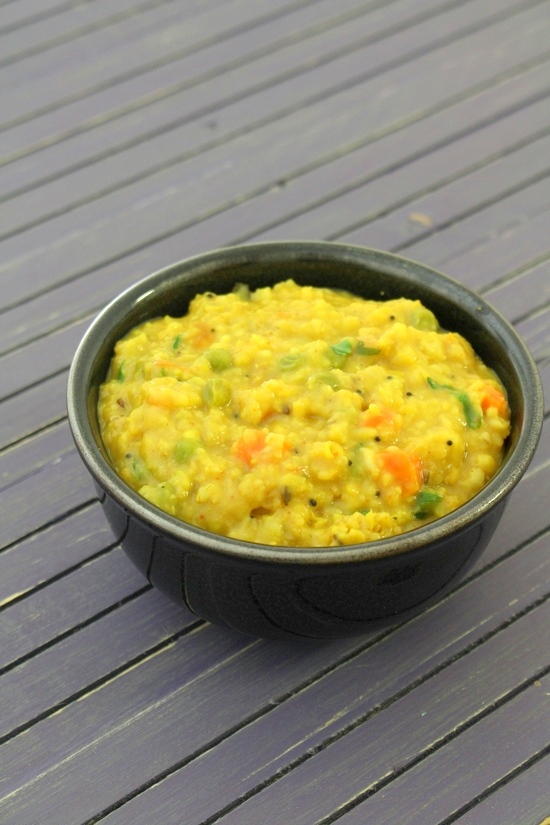 Oats khichdi in a black bowl.