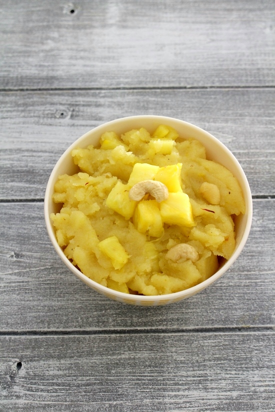 Pineapple halwa in a bowl garnished with pineapple pieces and cashew.
