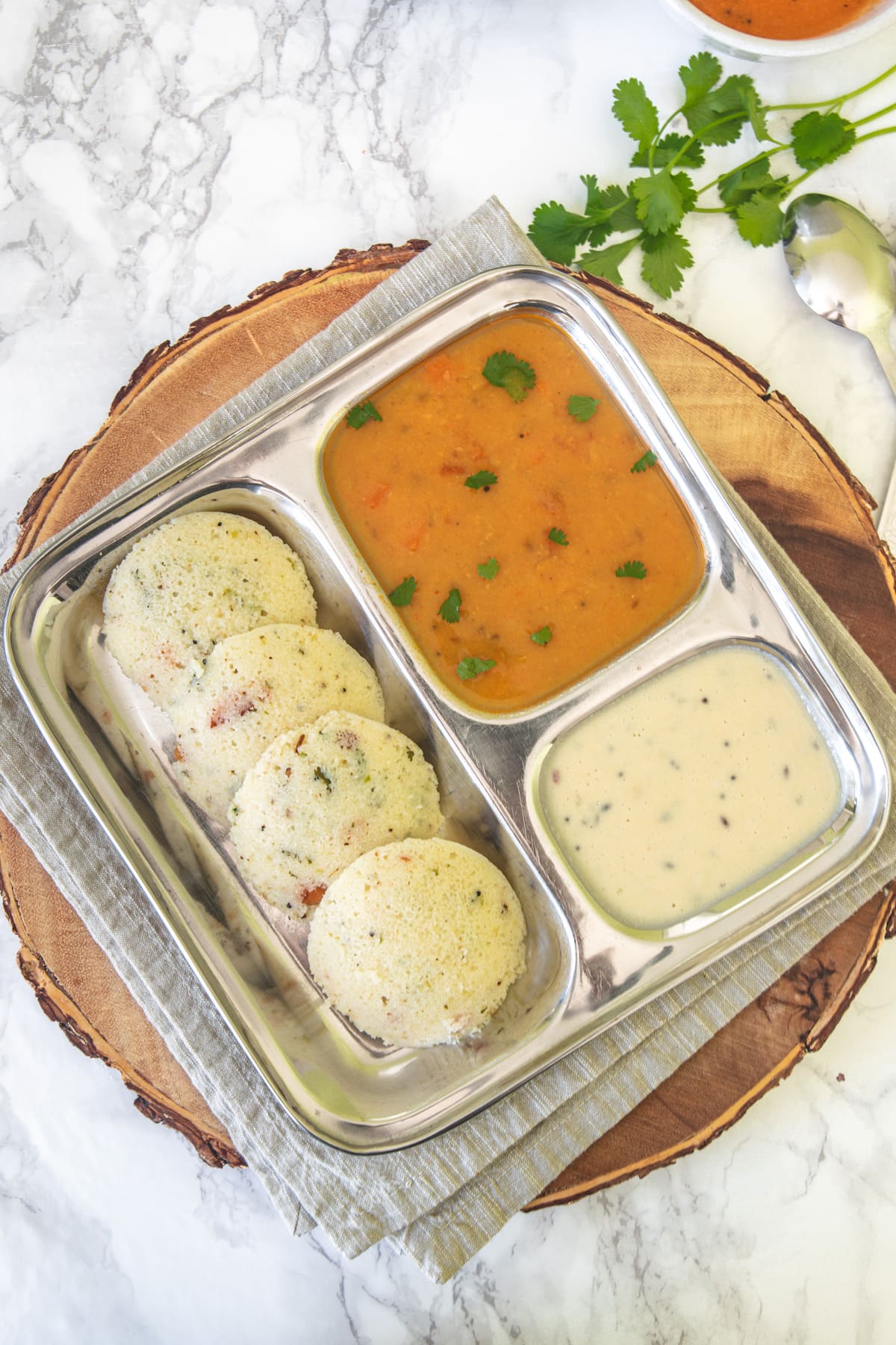 4 Rava idli served with sambar and coconut chutney.