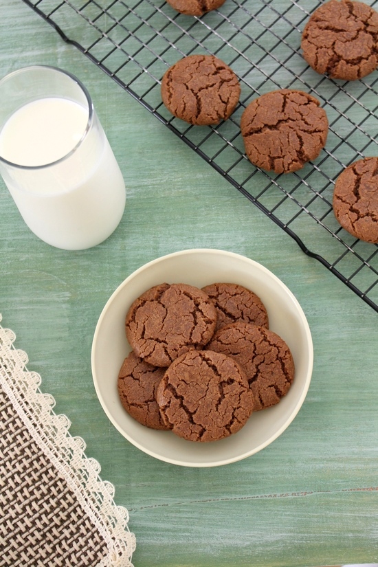 Eggless nutella cookies in a plate and on the rack with a glass of milk.