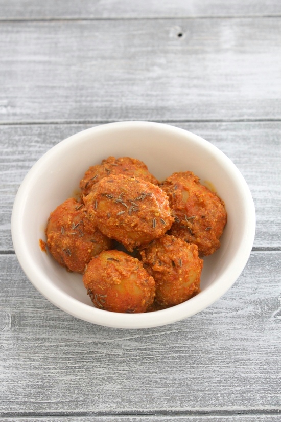 Kashmiri dum aloo in a bowl garnished with cumin seeds.