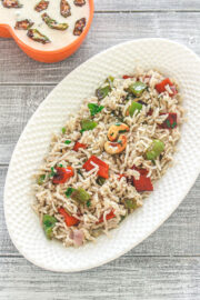 Capsicum pulao in an oval dish with bhindi raita.