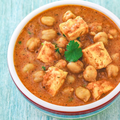 A bowl chole paneer garnished with cilantro.