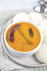 A bowl of sambar served with idli.