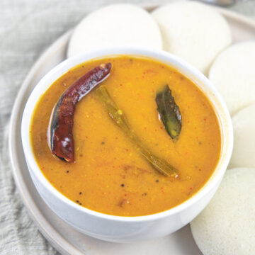 A bowl of sambar served with idli.