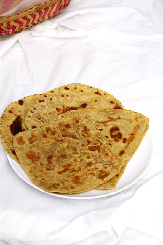 All shaped plain tawa paratha in a white plate.