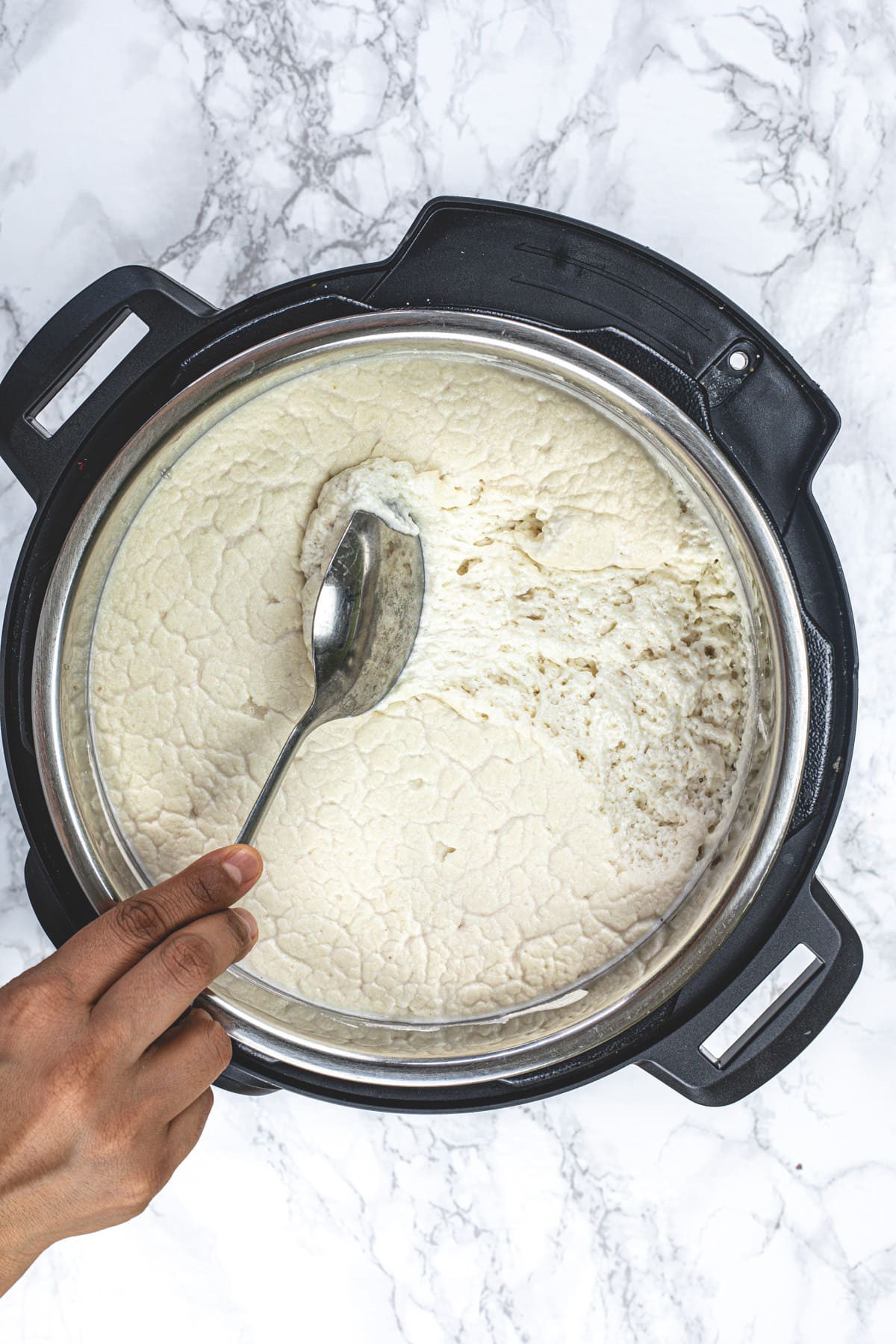 Showing texture of fermented idli batter using a spoon.