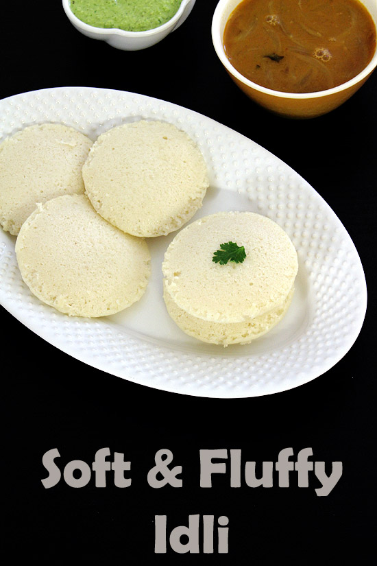 Idli served in a plate with sambar and chutney in the back.