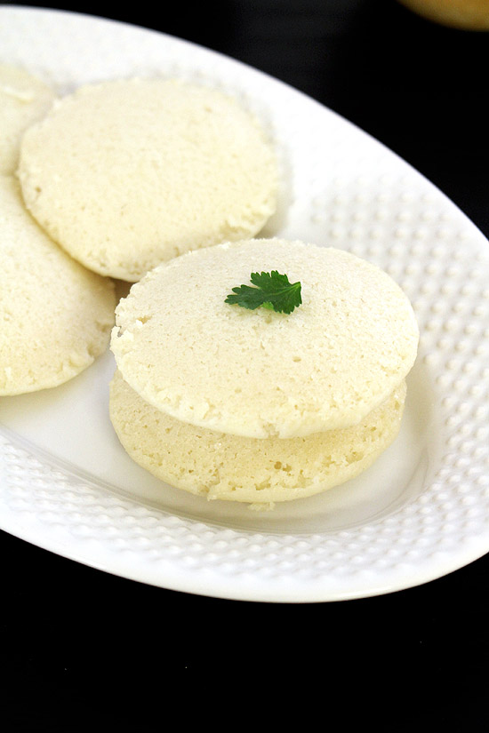 Idli in a plate garnished with cilantro.