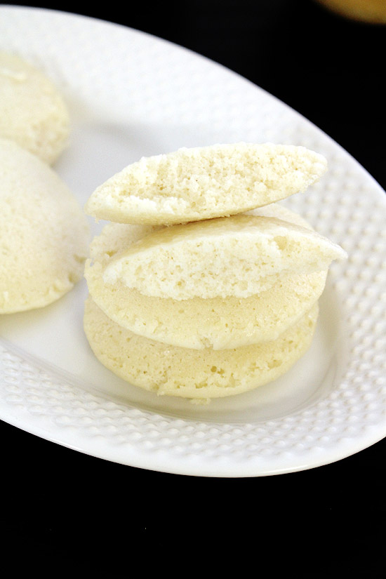 a stack of idli with one idli break into 2 pieces.