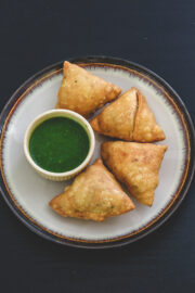 4 punjabi samosa with green chutney.