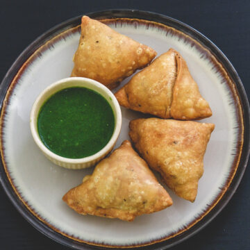 4 punjabi samosa with green chutney.