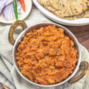 Baingan bharta served with bajra roti and onion, chilies on the side.