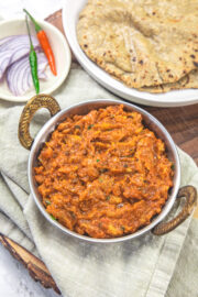 Baingan bharta served with bajra roti and onion, chilies on the side.