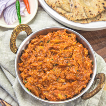 Baingan bharta served with bajra roti and onion, chilies on the side.