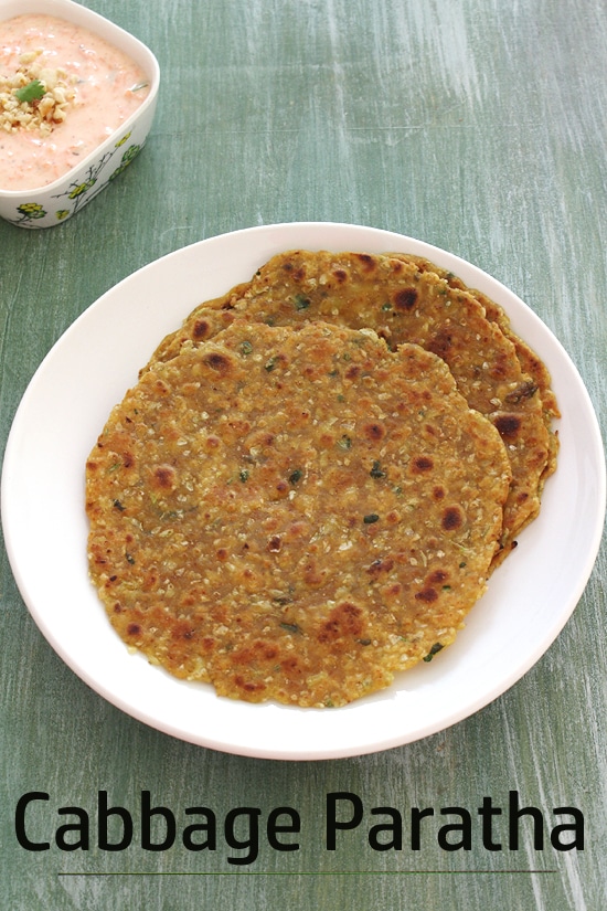 Cabbage paratha in a plate with carrot raita on a side.