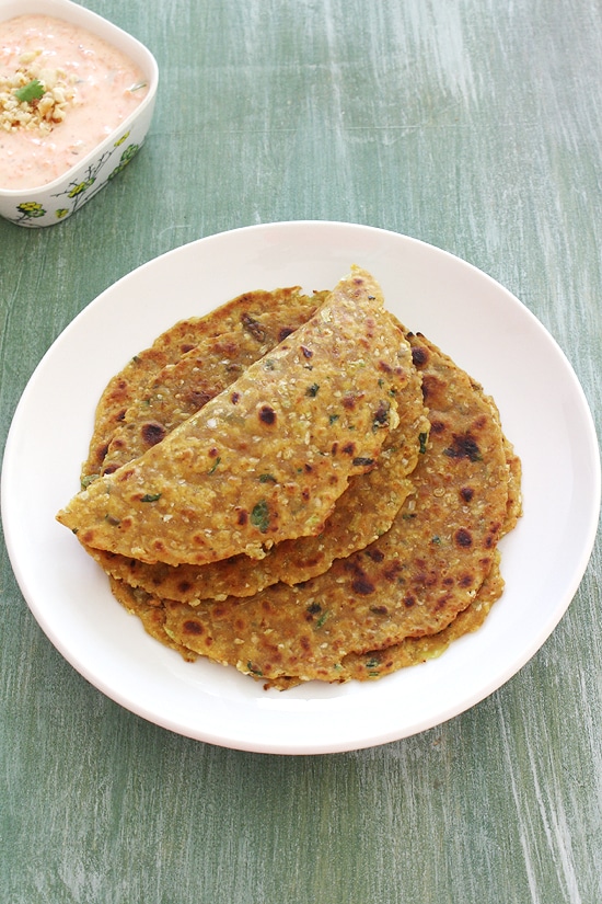 Cabbage paratha in a plate with first one folded in half.