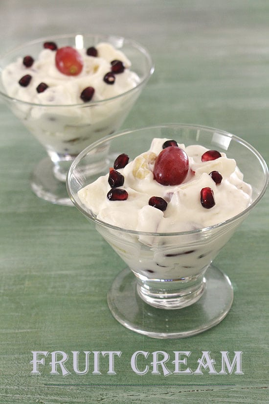 2 bowls of fruit cream garnished with pomegranate, grape and cashew.