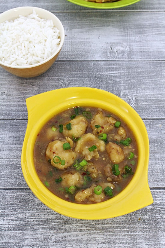 Gobi manchurian garnished with spring onion greens served with rice.