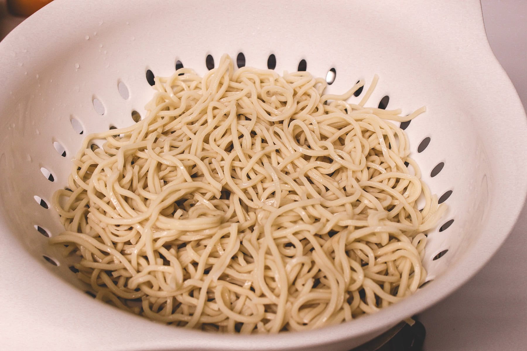 Boiled noodles in a colander.