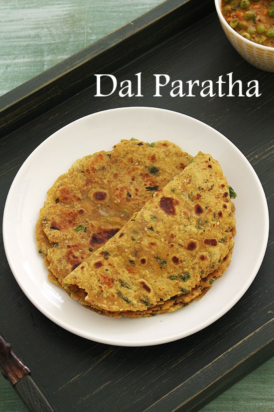 Dal paratha in a plate and first paratha folded in half.