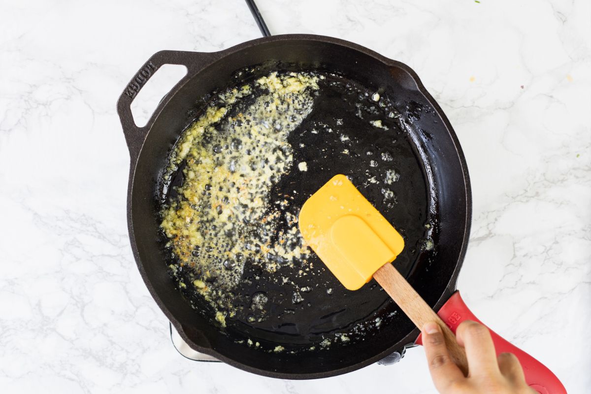 Sauteing ginger garlic in a cast iron pan.