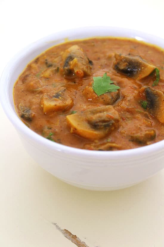 Mushroom masala in a bowl with a garnish of cilantro.