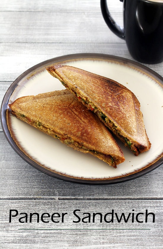 Paneer Sandwich in a plate with a black mug in the back.