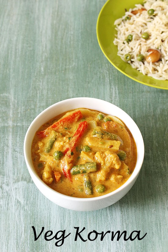 Veg kurma served in a bowl with rice in the back.